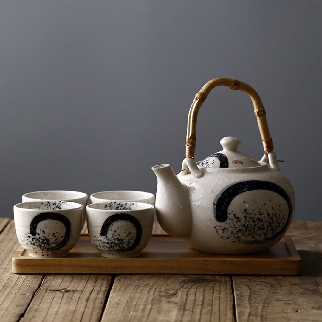 Un service de thé avec une théière et une tasse, de couleur grise.